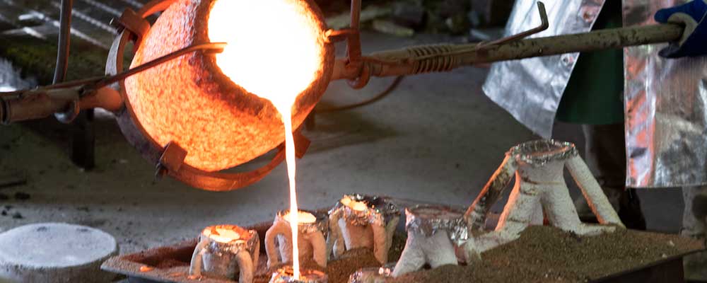 Image showing molten bronze being poured from a crucible.