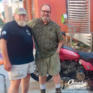 Artist Jeff Miller and client standing in front of Harley-Davidson motorcycle with custom bronze submarine veterans derby cover