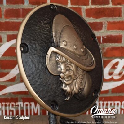 Custom cast bronze derby cover for Harley-Davidson motorcycle with Conquistador design